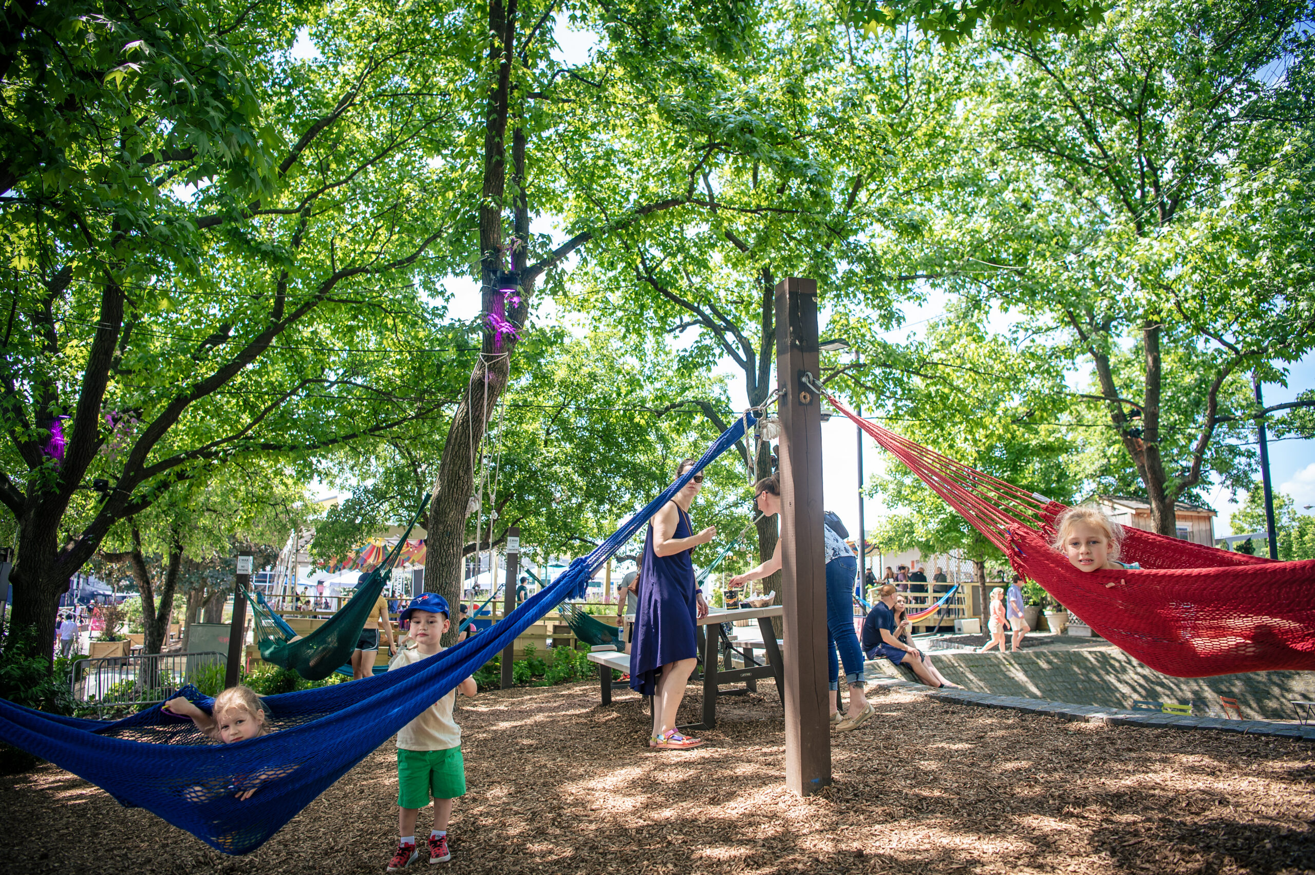 Los niños disfrutan de las emblemáticas hamacas del Spruce Street Harbor Park en Filadelfia, un destino ideal para familias situado a orillas del río Delaware. Crédito: Maria Young